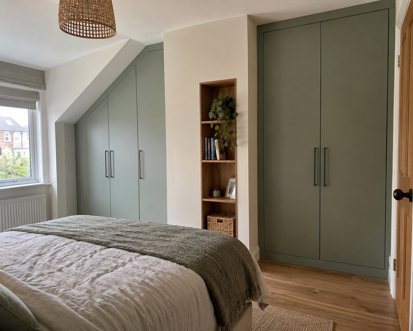 Sage fitted wardrobes built around a sloping bedroom ceiling
