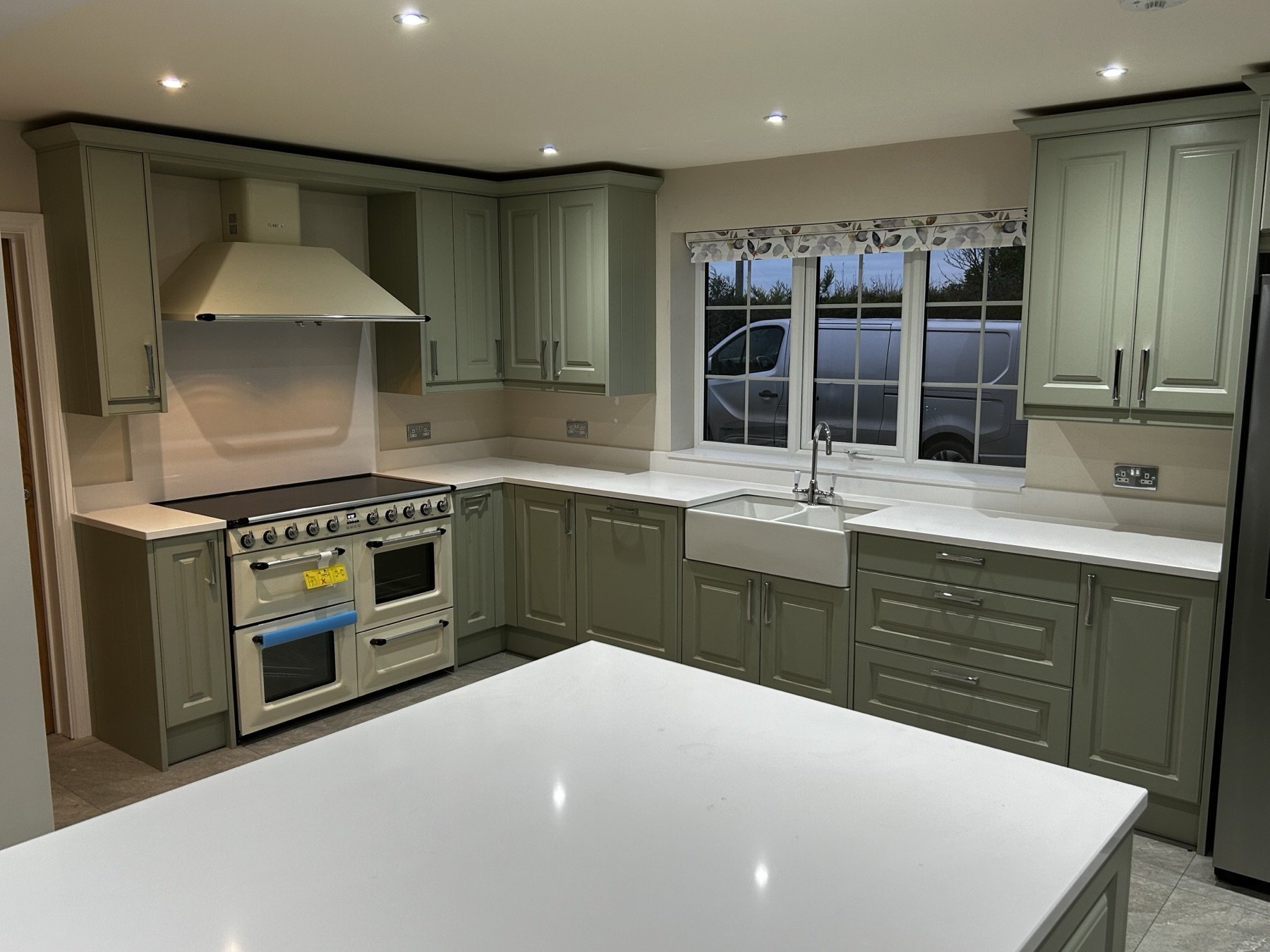 Sage green in-frame kitchen with cream range cooker, Belfast sink and quartz worktops