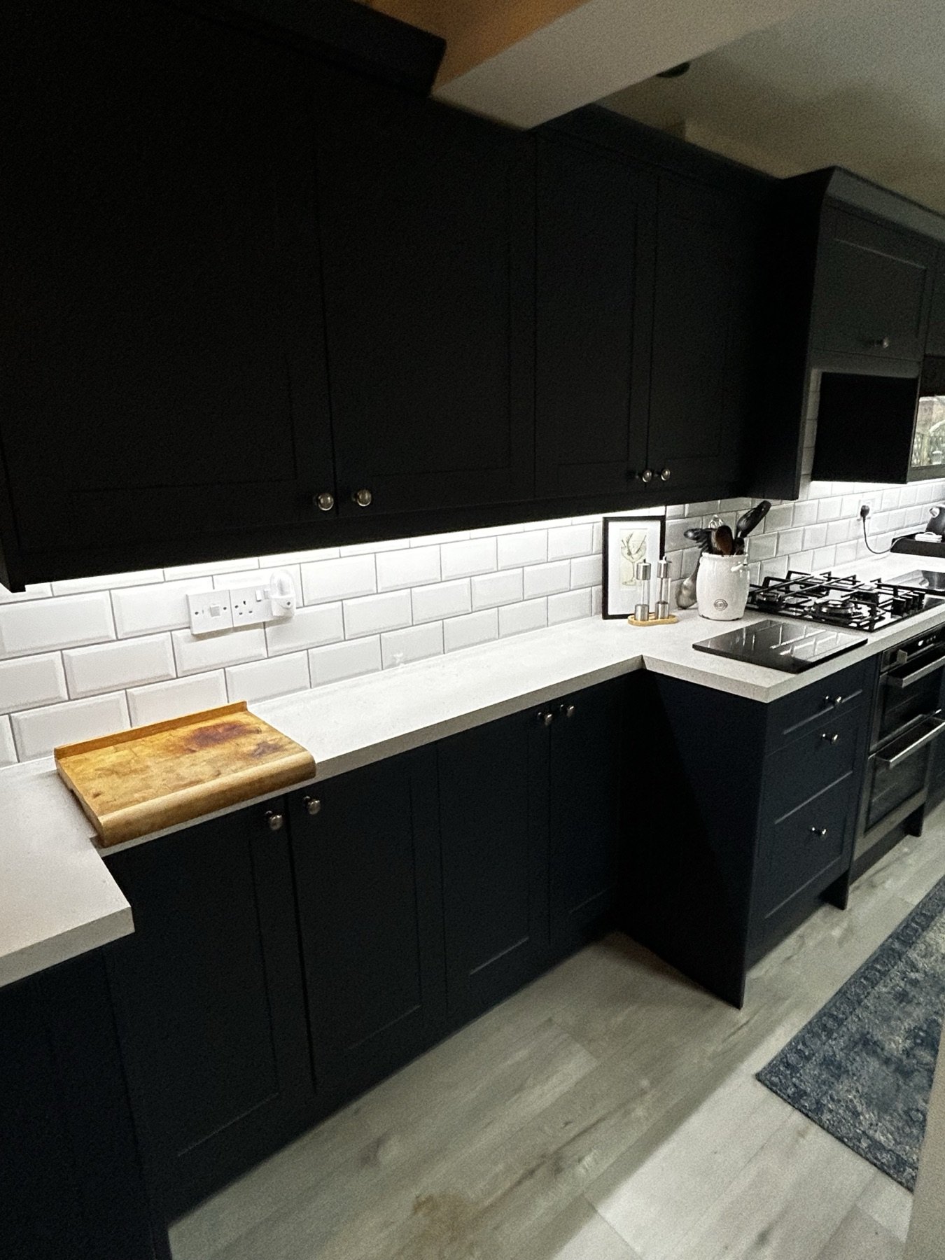Deep navy Shaker kitchen with metro tiles and engineered oak floor